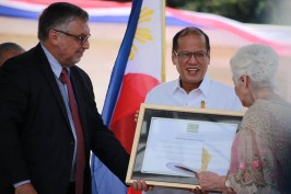 El Presidente Aquino sostiene el diploma en tributo a Quezón.